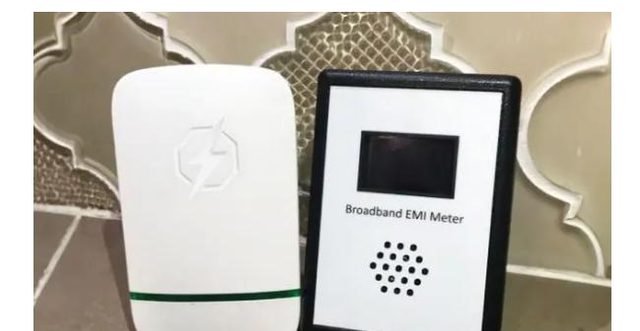 StopWatt plug-in device next to a broadband EMI meter